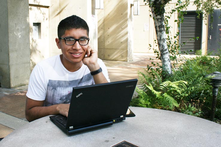 A student using a laptop outside.